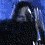 A person with long hair and a dark shirt appears in showing head movement against a blue background