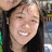 A pixelated image of a person with long dark hair smiling, surrounded by red text elements on a white background.