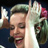 Static 48x48 pixel icon showing a close-up of a person with light brown hair wearing a white top, holding up a pink flower near their face against a dark background.