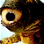 A pixelated close-up of a cartoon character's face with large brown eyes, dark hair, and a light blue background.
