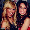 repeated images showing two women with blonde and brown hair, wearing dark sleeveless tops, with 'HEY!' text in yellow boxes below each pair