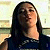 Pixelated portrait of a person with long dark hair wearing a dark top against a light background.