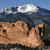 A pixelated landscape with a brown rocky formation under a blue sky with white clouds, rendered in low-resolution style.