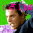 Pixelated image of a person with brown hair wearing a dark jacket over a light purple shirt against a bright green background with pink text elements.