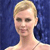 Pixelated close-up of a person with short blonde hair against a dark blue background, wearing a light-colored top.