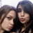 Two people with dark hair pose closely together in a pixelated image with light background.
