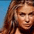 A pixelated image of a woman with long brown hair wearing a dark bikini top, positioned against a blue background.