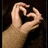 A hand forms a heart shape with fingers against a dark background, with a red 'love' text overlay in one frame.