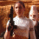 Two side-by-side figures in white shirts holding dark rifles against a brown textured background, with a blue and white logo below.