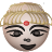 Pixelated circular icon shows a face with light brown hair, dark eyebrows, closed eyes, a red bindi on the forehead, and a smiling mouth against a gray background.