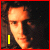 A four- shows a person with curly hair and dark clothing, where the lower-left displays text over the image