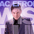 Pixelated image of a person in a gray jacket with a black collar, standing against a purple and white background with partial text "ACE" visible.