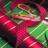 Pixelated static image with abstract red and green color patterns resembling blurred holiday lights or festive decorations on a dark background.