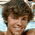 four pixelated images showing a person with brown hair in different poses and expressions, including a smiling face and a neutral face with a cap