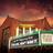 Pixelated image of a building facade with columns and a green sign under a gradient sky.