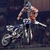 A rider on a dirt bike in mid-air, captured across three showing slight forward motion and rotation