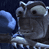 Pixelated gray cartoon character with large eyes and a blue wing-like shape on the left side against a dark background.