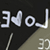 Pixelated static icon with white text and symbols on dark background, featuring a heart symbol replacing the 'o' in 'NoJ', partial number below, and diagonal gradient transition to beige area.