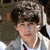 A person with brown hair and a light gray jacket over a white shirt appears in three showing slight head movement