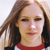 A pixelated close-up of a person with light brown hair wearing a red and white top against a light background.