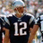 A pixelated image of a person in a dark blue sports jersey with white number 12, standing against a blurred background with red text reading 'Tom', 'Brady', and 'gorgeous' on a light blue field.