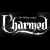 Static black-and-white pixelated logo with stylized text on a solid black background, appearing as a low-resolution digital rendering of the word "Charmed" in an ornate script font.