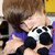 A person in a purple shirt holds a black-and-white spotted object with multiple circular shapes, positioned against a yellow and white background.