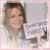A pixelated image of a person with brown hair wearing a light-colored top, holding a sign with partially visible text against a gray background.