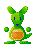 Green pixelated rabbit-like creature with blue eyes and mouth, holding an orange object against gray background.
