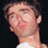 Pixelated close-up of a person's face and neck in profile against dark background, wearing light-colored shirt with visible collar.