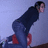 Pixelated figure in dark blue hoodie and red shoes stands against light purple background with slight tilt.