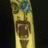 A vertical animated icon shows a yellow tiki mask with brown facial features and blue eyes, alternating between open and closed mouth expressions against a black background.