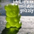 A static pixelated image shows a green cylindrical object with a dark base against a blurred background of light and dark gray tones.