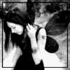 Black-and-white animated sequence of a woman with long dark hair in profile, wearing a dark dress and light-colored gloves, her right hand raised near her face.