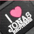 Black background with pink heart and white text "I LOVE YOU" in pixelated font, partially visible colorful object below.