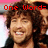 A pixelated image of a person with curly brown hair smiling, overlaid with red text reading "One Word= Amazing" and "Elliott Yamin" in different sections.