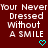 Red background with white pixelated text reading 'Your Never Dressed Without A Smile' and two cyan heart symbols at bottom right.
