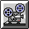 Pixelated film projector with two reels, gray body, blue-and-black spools, red indicator light on base.