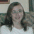 A pixelated image of a person with long brown hair wearing a white shirt, alongside purple pixelated text on black and gray backgrounds.