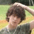 A pixelated image of a person with brown hair in a grassy outdoor setting, paired with text on a black background