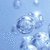 Pixelated blue background with multiple translucent bubbles of varying sizes floating upward, some overlapping, with light reflections on their surfaces.