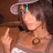 A person wearing a light purple hat and brown top with a circular design points with their right index finger while text changes from 'i' to 'hate' to 'u' in cyan.