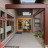 Pixelated static image of a house exterior with brown trim, white walls, and greenery visible through windows.