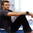 Pixelated static image of a person in dark clothing extending an arm horizontally with a neutral expression against a light background.