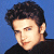 Pixelated image of a person with dark curly hair against blue background, next to green text reading Original Icons .com in bright green pixel font.