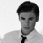 A black-and-white image of a person in a white shirt and dark tie with red pixelated text reading "IT'S SMOCKEDY BIIIIATCH" overlaid on the right side.