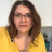 Pixelated static image of a person with shoulder-length brown hair wearing a yellow top against a light background.