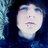 A pixelated image of a person with dark hair and blue eyes, overlaid on a black background with blue text reading "Alex evans" and "Loves me."