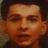 Pixelated close-up of a person's face with dark hair, neutral expression, and visible mouth opening.