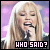 A pixelated image of a person with long blonde hair singing into a microphone, overlaid with text reading "WHO SAID?" in white and pink lettering.